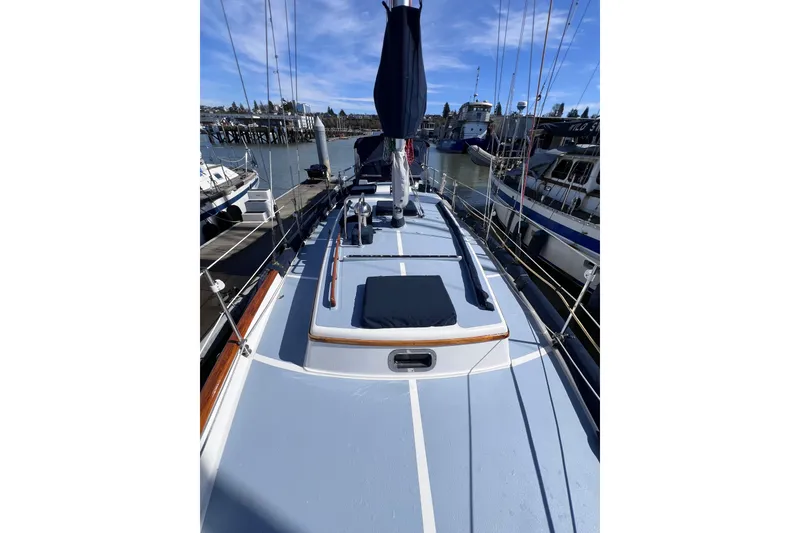 Slide: The Image of 1990 Cabo Rico 38R sailboat docked, showcasing deck and rigging under clear blue sky. - 20