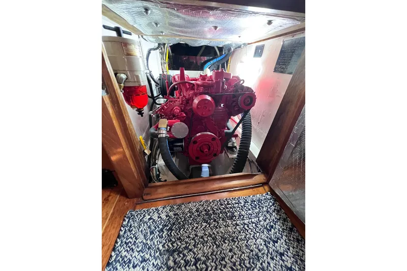 Slide: The Image of Engine compartment of a 1990 Cabo Rico 38R sailboat, featuring a red engine. - 30