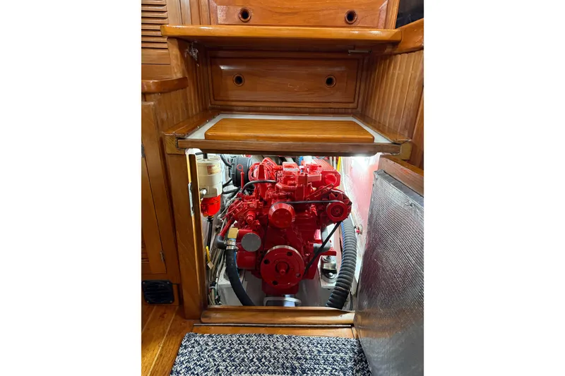 Slide: The Image of Engine compartment of a 1990 Cabo Rico 38R sailboat, featuring a red engine. - 33