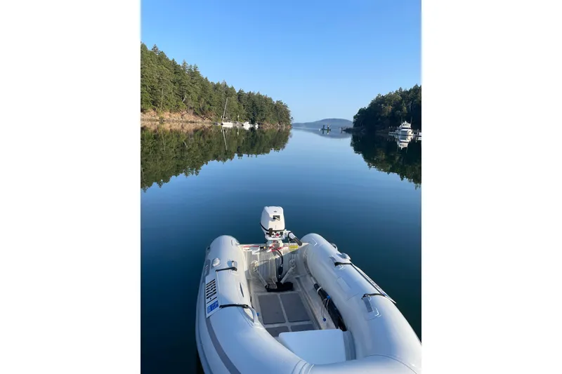 Slide: The Image of Calm waters with a Cabo Rico 38R sailboat, 1990 model, in a serene forested bay. - 36