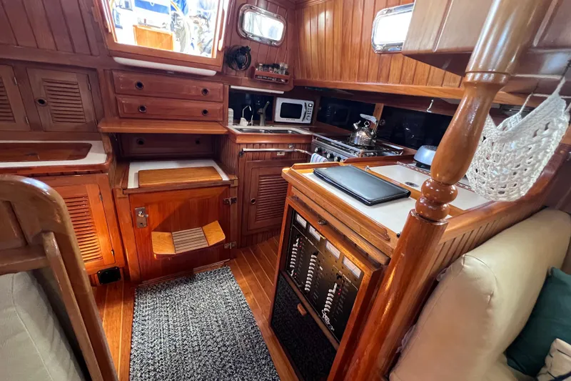 Slide: The Image of Cozy 1990 Cabo Rico 38R yacht interior with wooden cabinetry and modern kitchen amenities. - 4