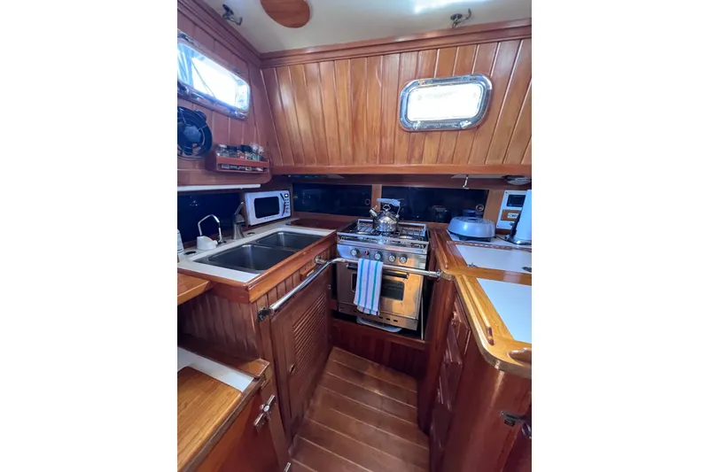 Slide: The Image of Cozy wooden galley in 1990 Cabo Rico 38R sailboat with stove, sink, and microwave. - 7