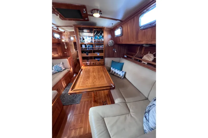 Slide: The Image of Luxurious 1990 Cabo Rico 38R yacht interior with elegant wood finish and cozy seating area. - 9