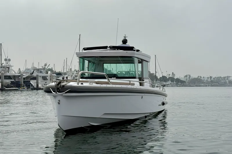 Slide: The Image of 2023 Axopar 28 Cabin boat on calm water near marina. - 16