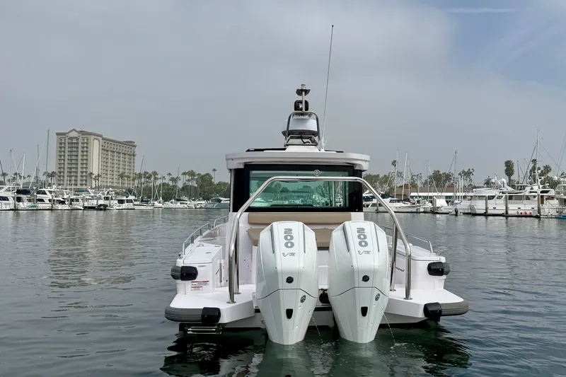 Slide: The Image of 2023 Axopar 28 Cabin boat with dual engines docked in a marina. - 17