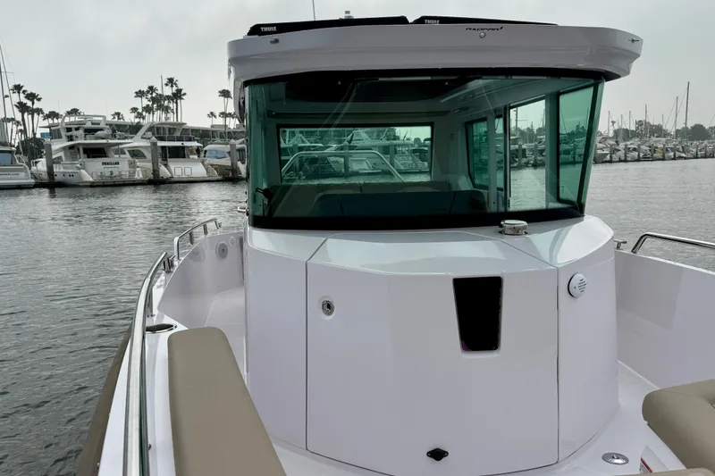 Slide: The Image of 2023 Axopar 28 Cabin boat docked in a marina, showcasing sleek design and modern features. - 19