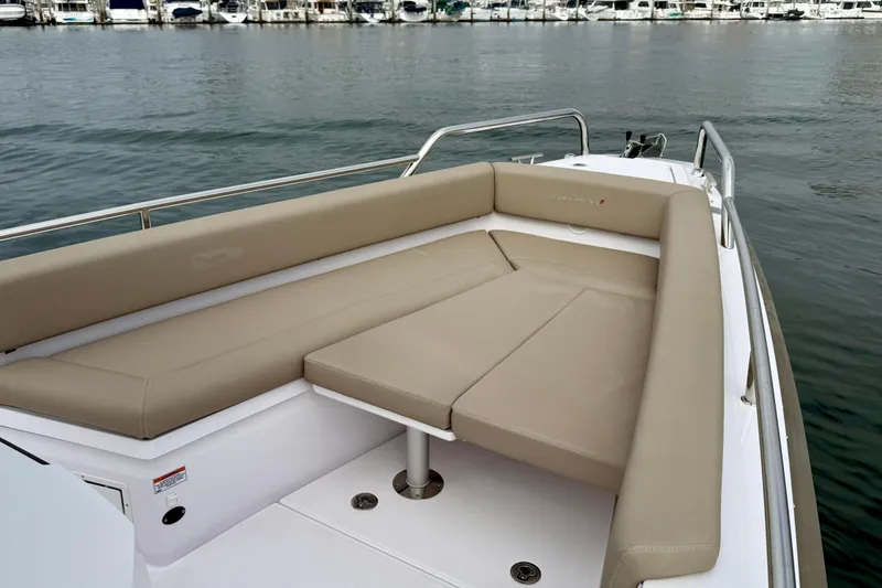 Slide: The Image of 2023 Axopar 28 Cabin boat with beige seating, docked by the water. - 24