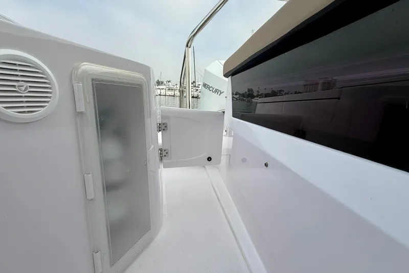 Slide: The Image of 2023 Axopar 28 Cabin boat interior with open storage compartment and speaker. - 25