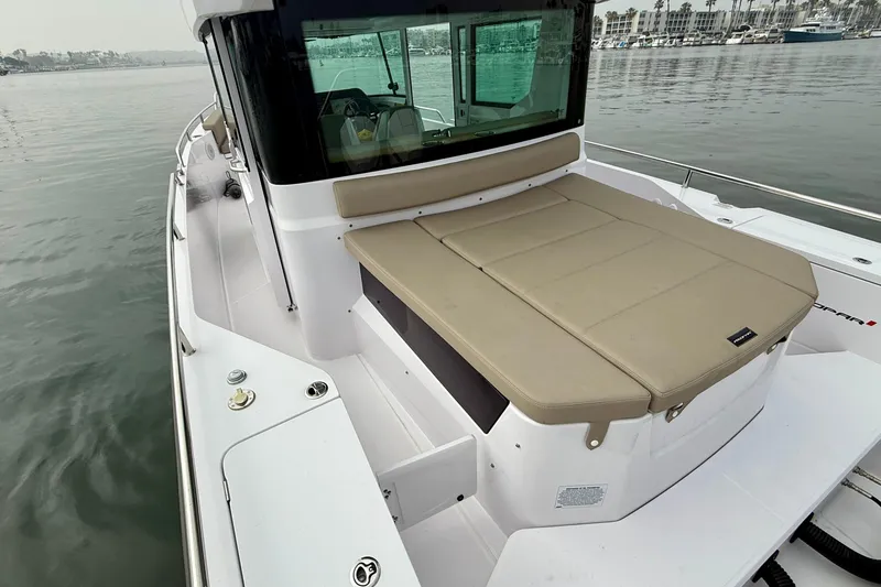 Slide: The Image of 2023 Axopar 28 Cabin boat with beige seating, docked in a marina. - 26