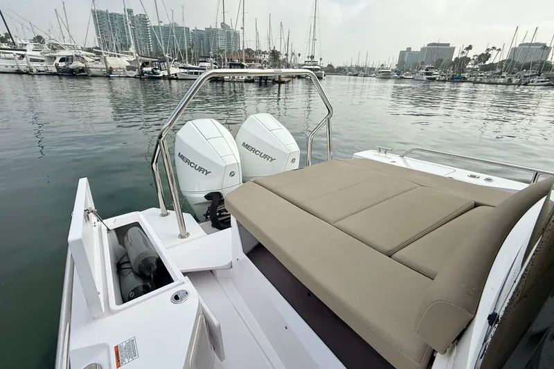 Slide: The Image of 2023 Axopar 28 Cabin boat with twin Mercury engines docked in a marina. - 27