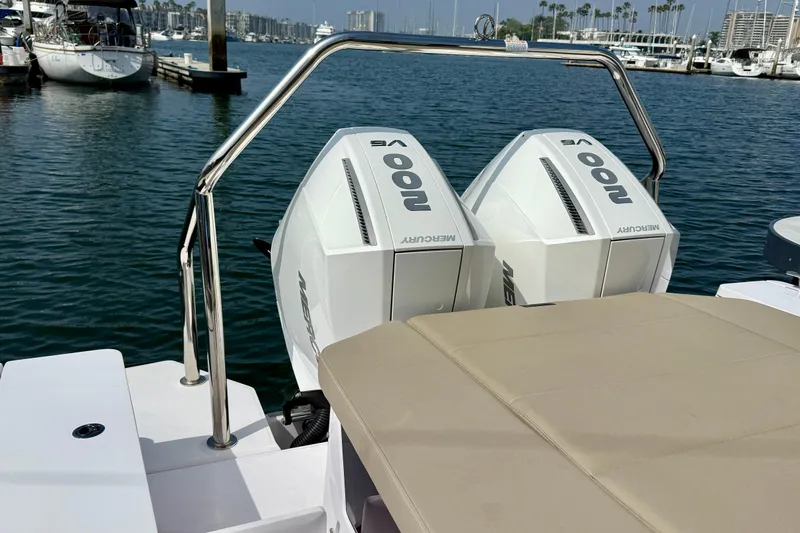 Slide: The Image of 2023 Axopar 28 Cabin boat with twin Mercury outboard engines docked in a marina. - 28