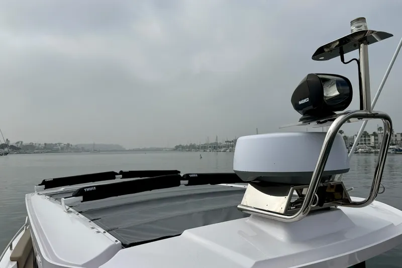 Slide: The Image of 2023 Axopar 28 Cabin boat with radar and spotlight on calm waters. - 30