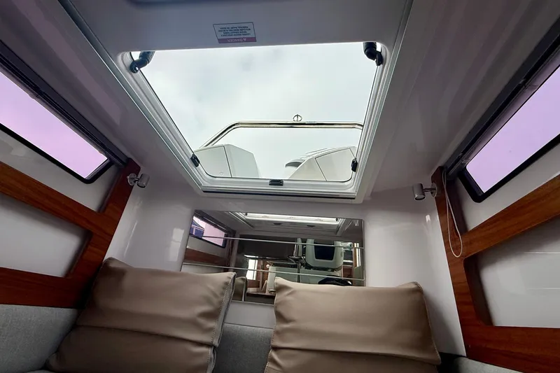 Slide: The Image of Interior view of 2023 Axopar 28 Cabin, featuring skylight and comfortable seating. - 41