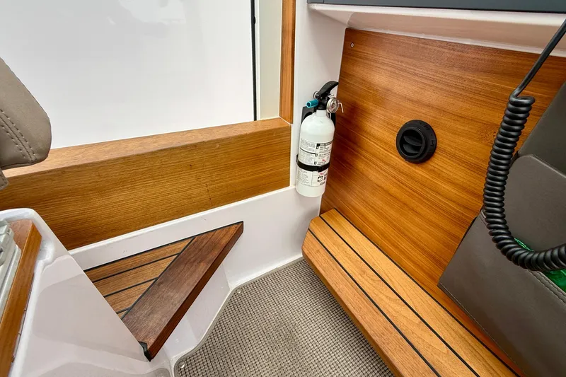 Slide: The Image of Interior of 2023 Axopar 28 Cabin with wood paneling and fire extinguisher. - 43