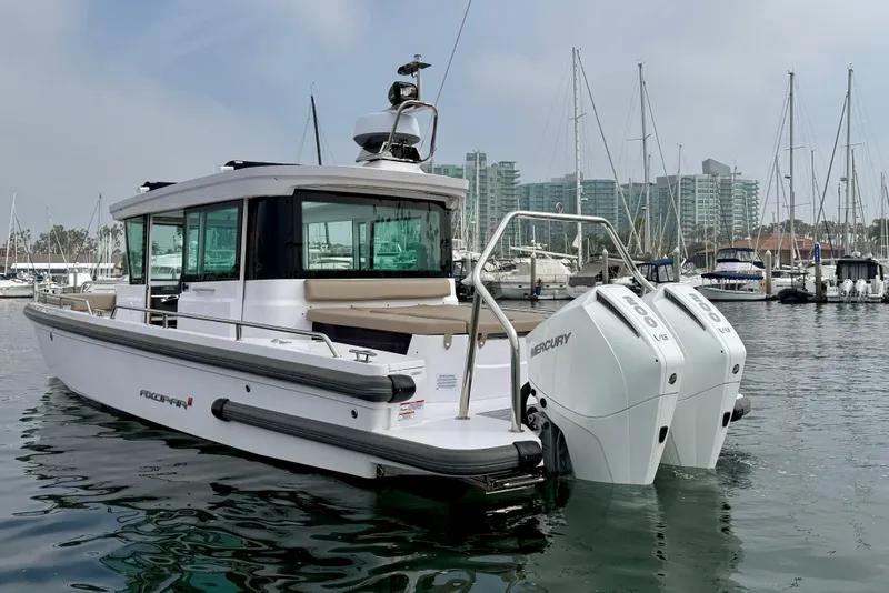 Slide: The Image of 2023 Axopar 28 Cabin boat with twin Mercury engines docked in marina. - 6