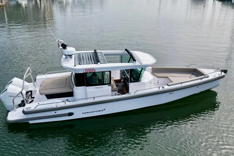 Slide: The Image of 2023 Axopar 28 Cabin boat on calm water, showcasing sleek design and modern features. - 8
