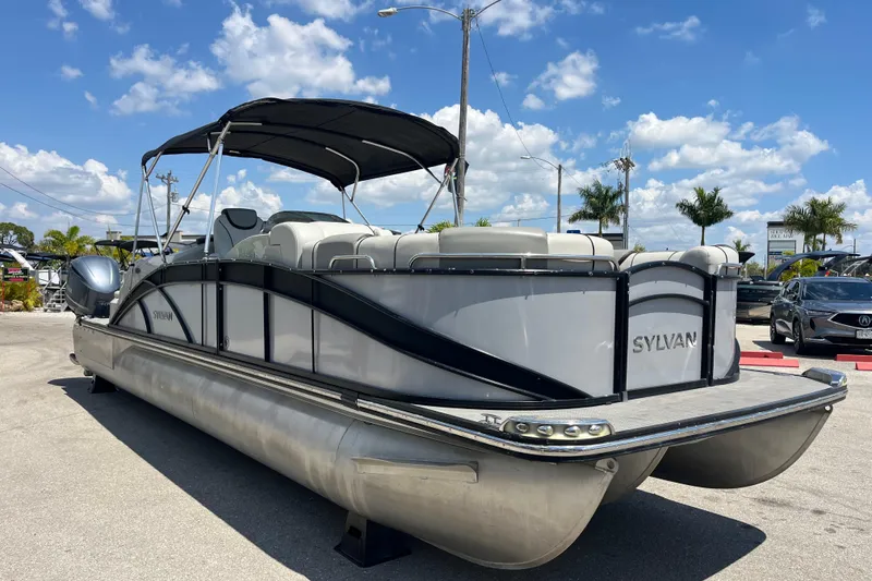Slide: The Image of 2017 Sylvan Mandalay 8525 Sportlounger Twin pontoon boat with canopy, parked outdoors. - 3