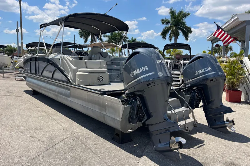 Slide: The Image of 2017 Sylvan Mandalay 8525 Sportlounger Twin pontoon boat with Yamaha engines, docked outdoors. - 6
