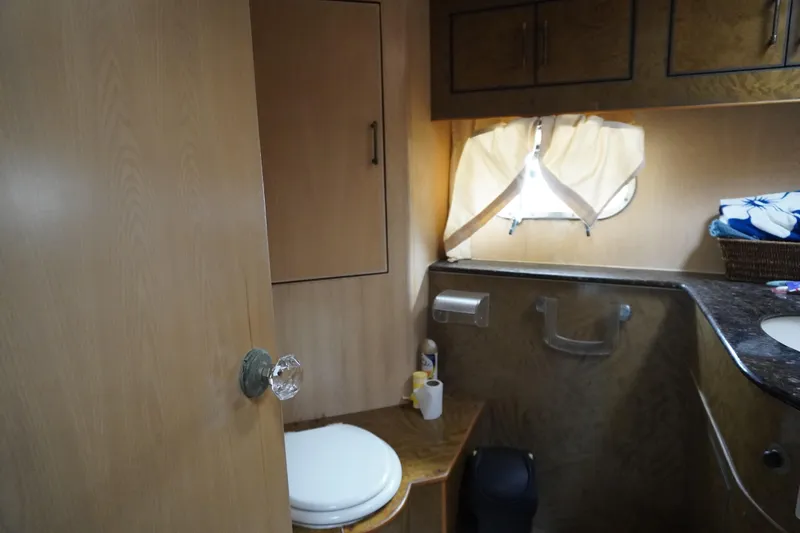 Slide: The Image of Interior of 1992 Horizon Power Boat bathroom with wooden cabinets and small window. - 12