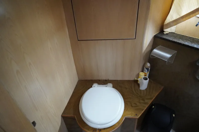 Slide: The Image of Bathroom interior of a 1992 Horizon Power Boat with wooden paneling and toilet. - 14