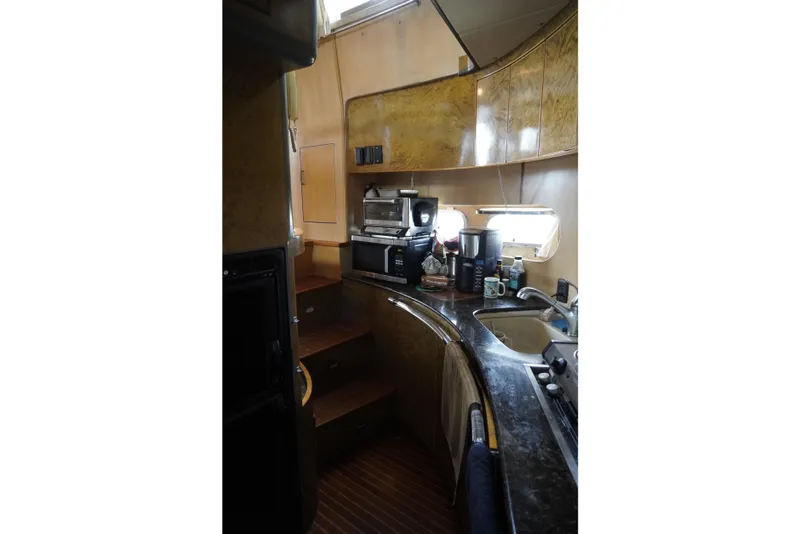 Slide: The Image of Interior of a 1992 Horizon Power Boat kitchen with appliances and wooden cabinetry. - 18