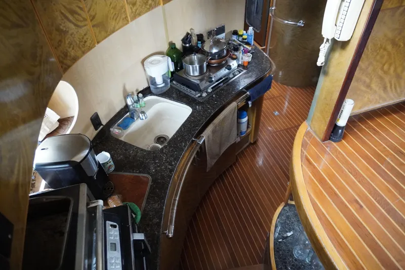 Slide: The Image of Compact kitchen area in a 1992 Horizon Power Boat with wooden flooring and modern appliances. - 19