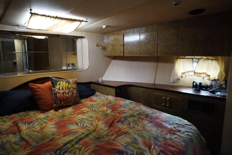 Slide: The Image of Cozy bedroom in 1992 Horizon Power Boat with tropical decor and wooden cabinetry. - 7
