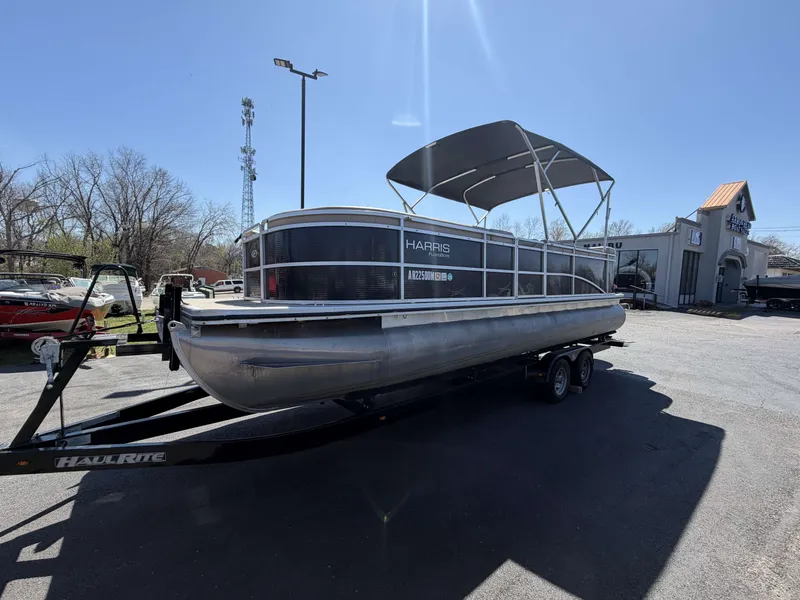 The Image of 2013 Harris Cruiser 240 pontoon boat on trailer outdoors. - 1