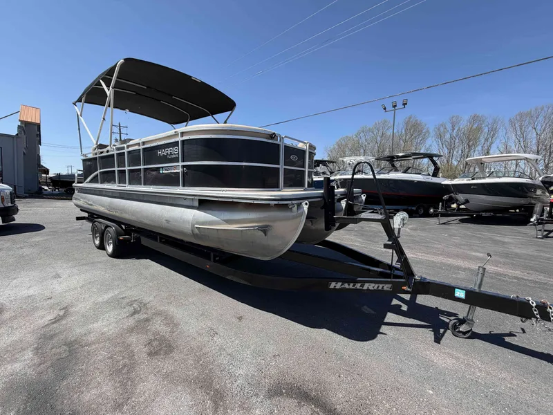 Slide: The Image of 2013 Harris Cruiser 240 pontoon boat parked on trailer outdoors. - 5