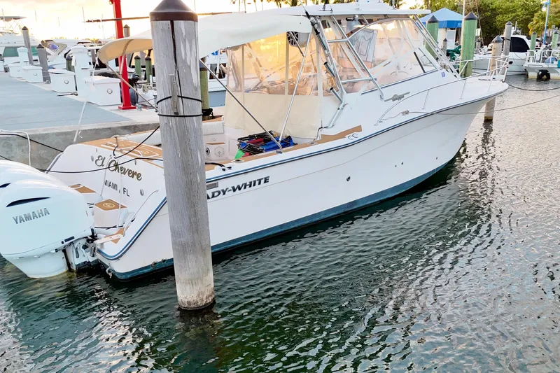 Slide: The Image of 2006 Grady-White Express 330 boat docked, featuring Yamaha engines, in a marina setting. - 12