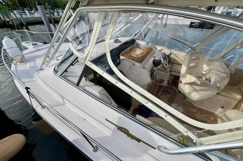 Slide: The Image of 2006 Grady-White Express 330 boat interior with helm and seating, docked by the water. - 13