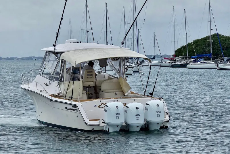 Slide: The Image of 2006 Grady-White Express 330 boat with triple Yamaha engines in a marina setting. - 15