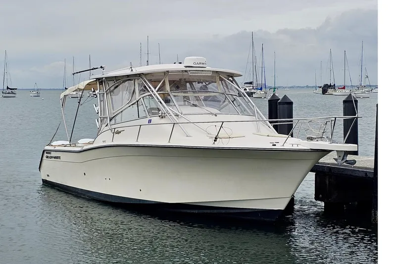 Slide: The Image of 2006 Grady-White Express 330 boat docked in a marina with sailboats in the background. - 19