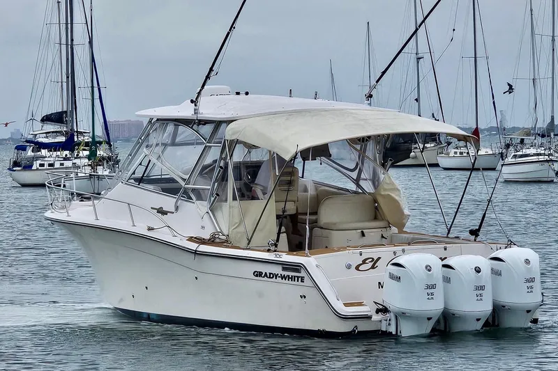 Slide: The Image of 2006 Grady-White Express 330 boat with triple Yamaha engines in a marina setting. - 20
