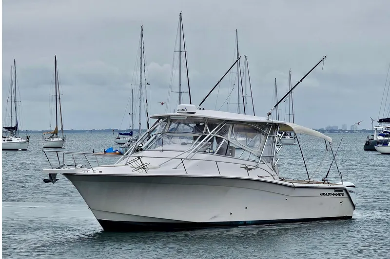 Slide: The Image of 2006 Grady-White Express 330 boat on calm water with sailboats in background. - 21