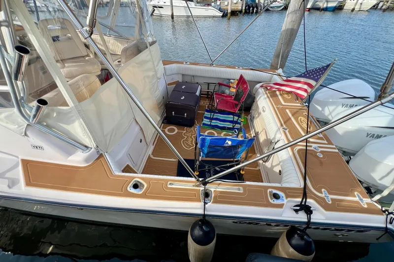 Slide: The Image of 2006 Grady-White Express 330 boat with seating, American flag, and docked at marina. - 25