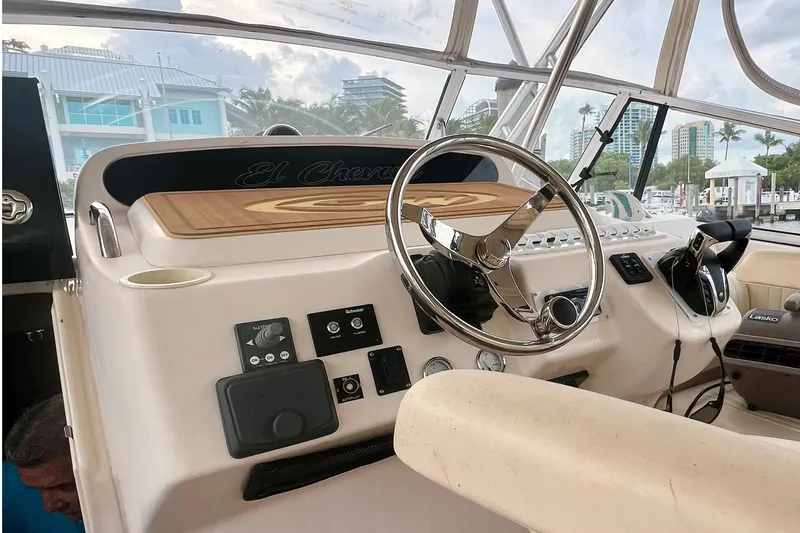 Slide: The Image of 2006 Grady-White Express 330 helm with steering wheel and control panel, docked at marina. - 29