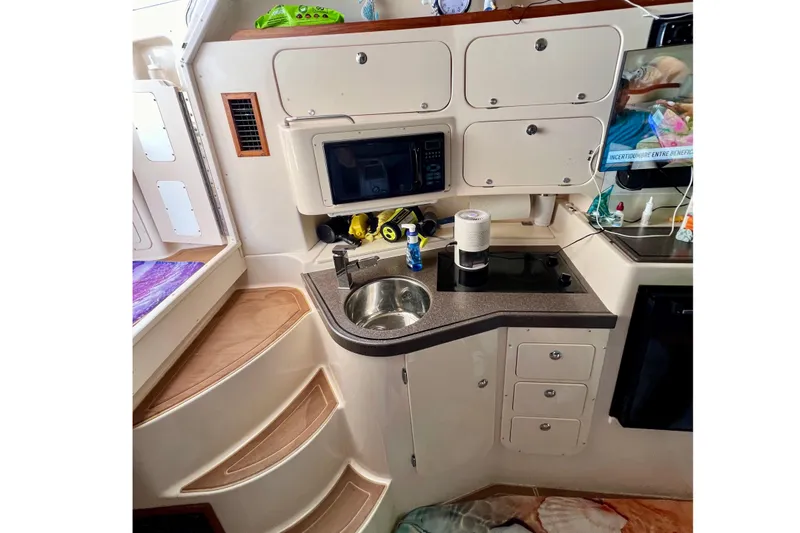 Slide: The Image of Compact kitchen area in a 2006 Grady-White Express 330 boat, featuring a sink and microwave. - 32