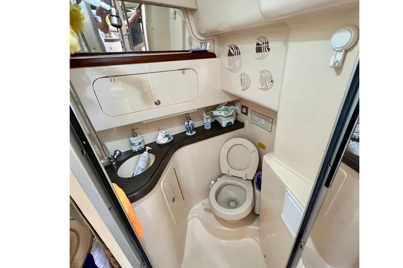 Slide: The Image of 2006 Grady-White Express 330 boat bathroom with sink, toilet, and storage cabinets. - 33