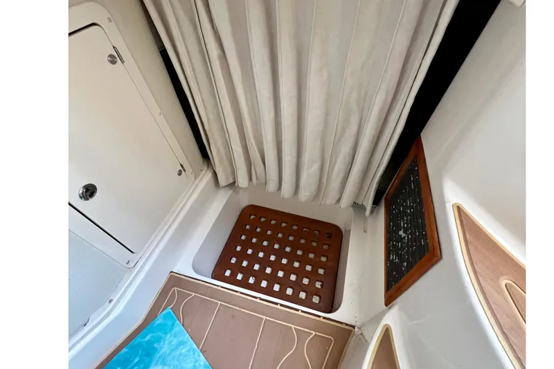 Slide: The Image of Interior of 2006 Grady-White Express 330 boat, featuring a shower area with curtain and wooden floor. - 36
