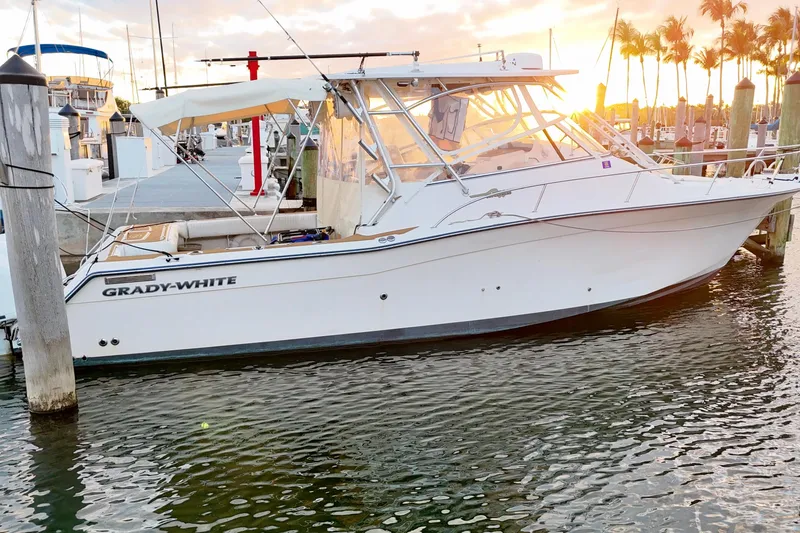 Slide: The Image of 2006 Grady-White Express 330 boat docked at sunset with palm trees in background. - 8