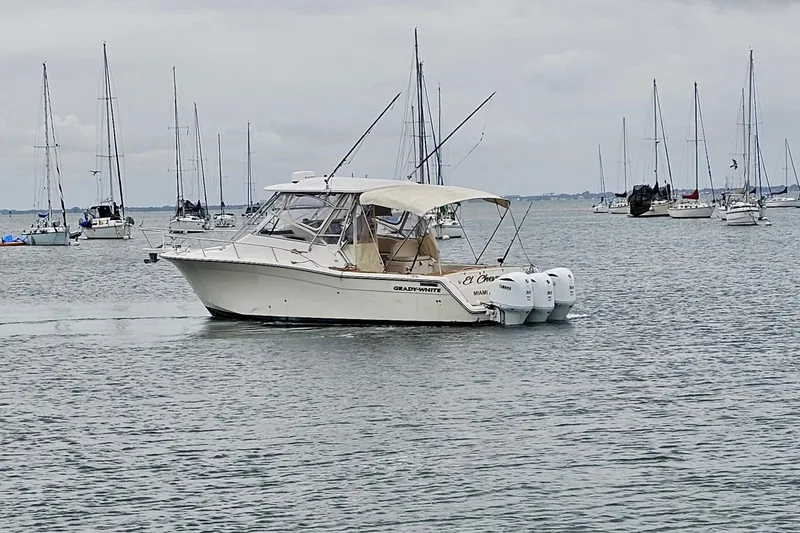 Slide: The Image of 2006 Grady-White Express 330 boat on calm water with sailboats in background. - 9