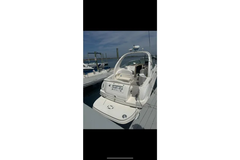 Slide: The Image of 2002 Sea Ray Sundancer 280 docked at marina, showcasing sleek design and spacious deck. - 10