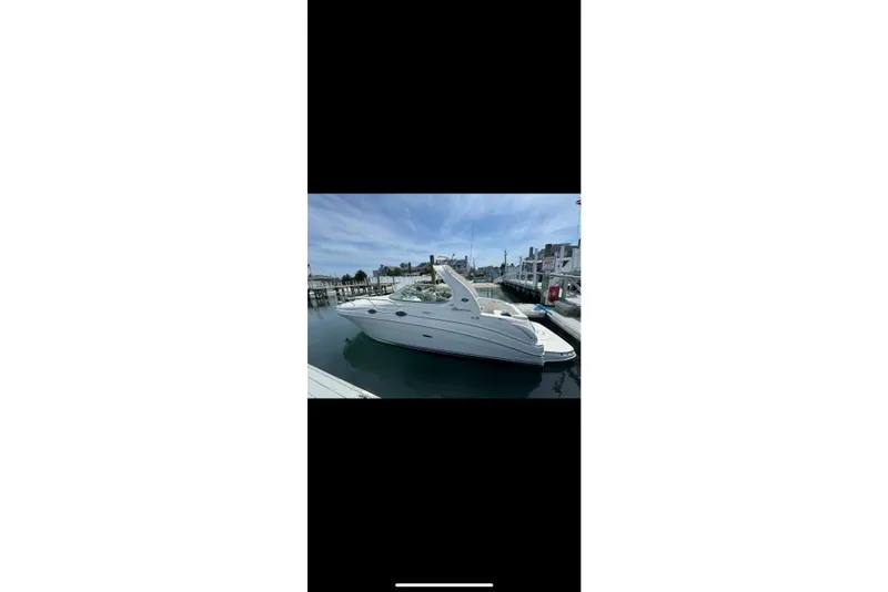 Slide: The Image of 2002 Sea Ray Sundancer 280 docked at a marina under a clear blue sky. - 11