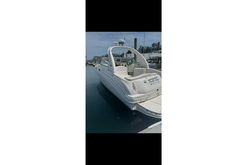 Slide: The Image of 2002 Sea Ray Sundancer 280 docked at marina, showcasing sleek design and spacious deck. - 9