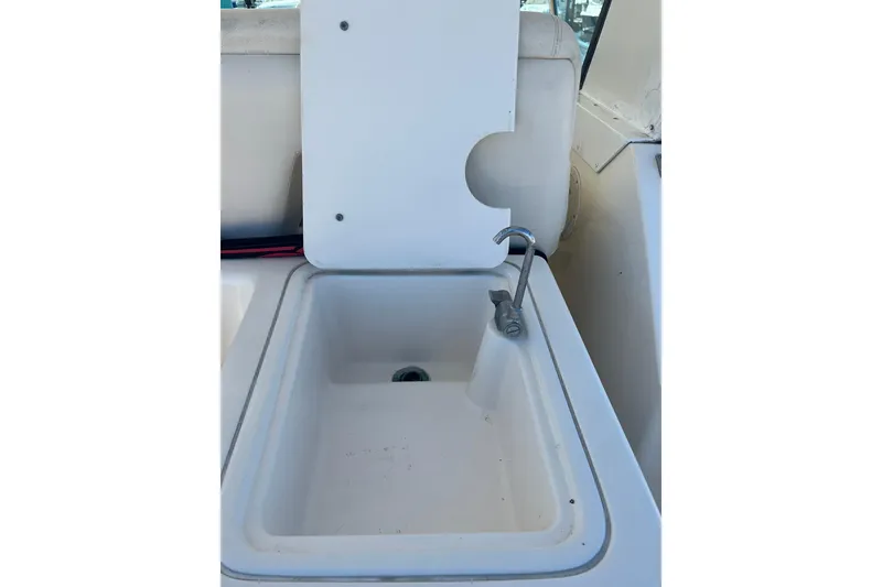 Slide: The Image of Sink area on a 1996 Tiara Yachts 3500 Express boat, featuring a faucet and cover. - 13