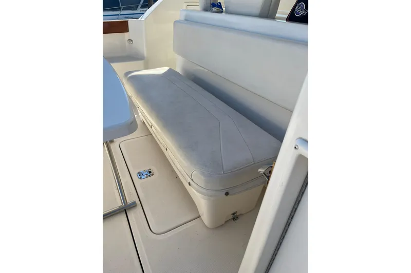 Slide: The Image of 1996 Tiara Yachts 3500 Express interior seating area with white cushioned bench. - 16