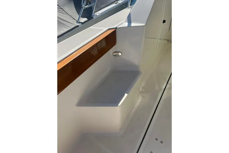 Slide: The Image of 1996 Tiara Yachts 3500 Express boat deck with wooden trim and seating area. - 21