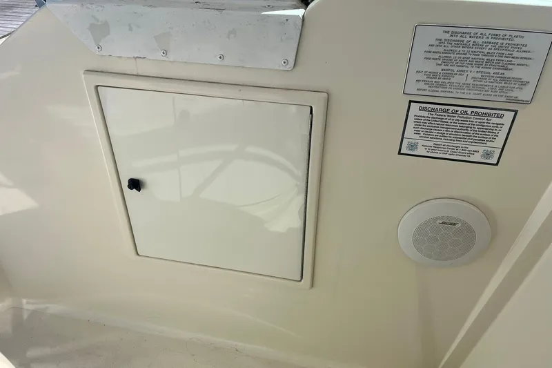 Slide: The Image of 1996 Tiara Yachts 3500 Express interior with storage compartment and safety notices. - 22