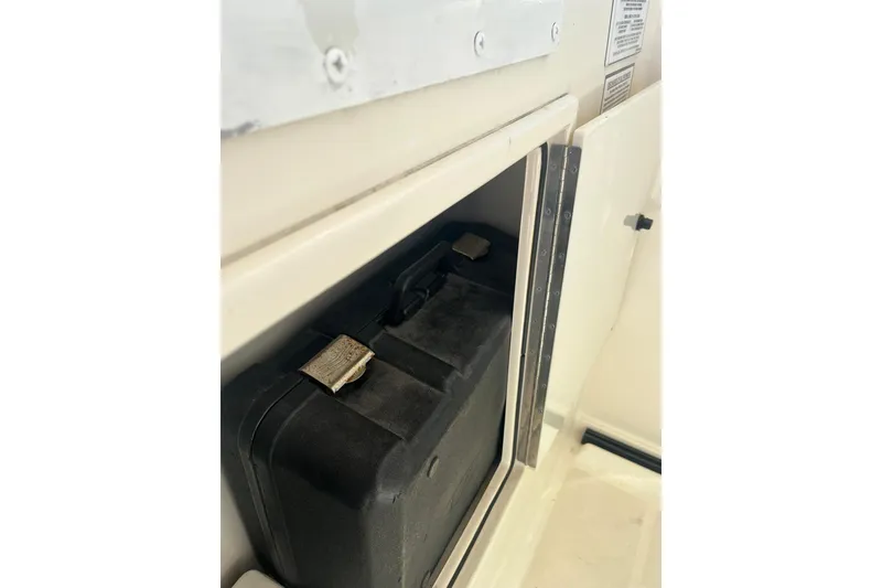 Slide: The Image of Storage compartment on a 1996 Tiara Yachts 3500 Express, featuring a secured black case. - 24